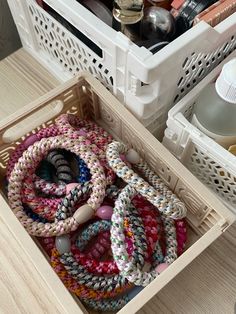 an open drawer with various items in it and on the floor next to other containers