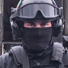 a man wearing a helmet and goggles with his face covered by a black mask