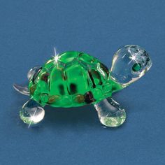 a green turtle figurine sitting on top of a blue surface