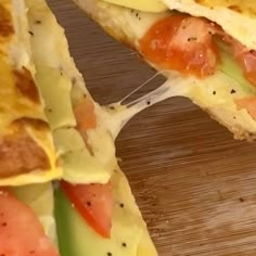 an omelet with tomatoes, cheese and other toppings is cut in half