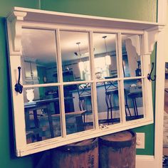 an old window in the corner of a room with two stools and a table behind it