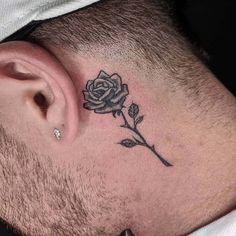 a man with a small rose tattoo on his side behind the ear is laying down