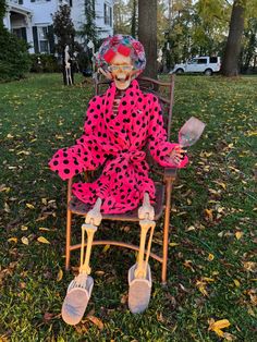 a creepy doll sitting in a chair on the grass