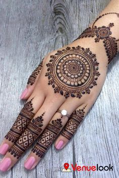 a woman's hand with henna tattoos on it