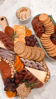 an assortment of cheeses, crackers, and meats on a platter