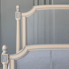 the headboard and foot board of an antique white bed with wicker design on it