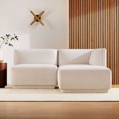 a white couch sitting on top of a hard wood floor next to a wooden wall