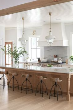 a kitchen with two stools next to an island