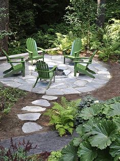 an outdoor fire pit surrounded by chairs and plants