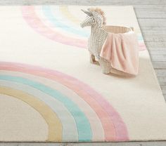 a rug with a toy horse on top of it and a rainbow rug in the background