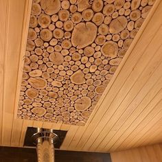 the ceiling is covered with wood logs and has a light fixture in front of it