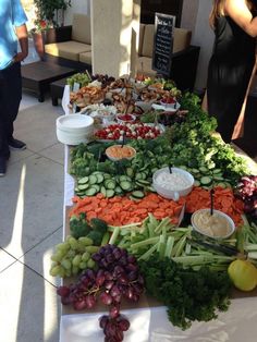 a long table filled with lots of different types of fruits and veggies on it