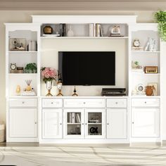 a living room with white cabinets and a flat screen tv on top of the entertainment center