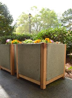 two cement planters with flowers in them