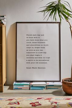 a poster with a poem on it sitting next to a potted plant and books