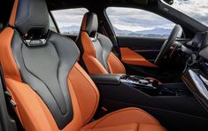 the interior of a sports car with orange leather seats