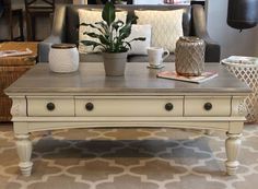 a living room filled with furniture and a coffee table on top of a rug covered floor