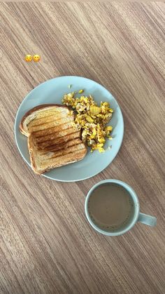 a plate with toast and scrambled eggs next to a cup of coffee