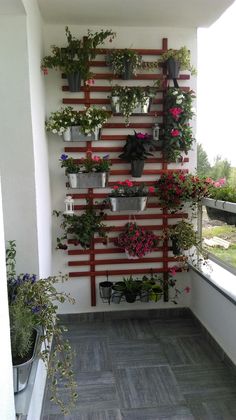 a wall mounted planter filled with potted plants on top of a tiled floor