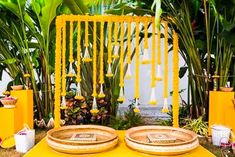 two plates sitting on top of a table covered in yellow flowers and greenery next to plants