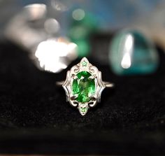 Gorgeous LARGE Green Tsavorite Garnets set in a stunning art deco style setting. This ring has all that glam and drama with the vibrant greens glowing off the high polished silver. There are two small Tsavorite Garnets that sit top and bottom of this ring. If you love rings with drama and color then this is definitely for you, the emerald greens from the natural Tsavorite will spark inspiration and pure joy. Its an all around BOMBSHELL of a ring.This ring is set in a size 8.Tsavorite Garnet: Cla Exquisite Green Emerald Sterling Silver Ring, Art Deco Emerald Jewelry With Gemstones, Art Deco Emerald Gemstone Jewelry, Green Sterling Silver Art Deco Jewelry, Art Deco Green Jewelry With Accent Stones, Green Art Deco Jewelry With Accent Stones, Art Deco Green Oval Emerald Ring, Elegant Tsavorite Rings With Polished Finish, Green Tsavorite Jewelry With Accent Stones