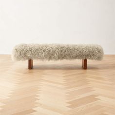 a white bench sitting on top of a hard wood floor