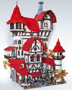 a building made out of legos with red roof tops and windows on the top