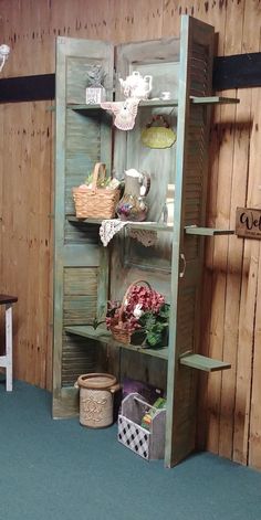 an old wooden shelf with baskets and flowers in it