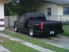 a black truck parked in front of a house