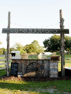 an outdoor bar set up in the middle of a field with lights strung over it