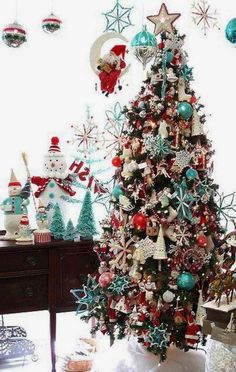 a decorated christmas tree in a living room with ornaments on the top and bottom of it