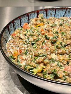 a bowl filled with lots of food on top of a metal counter next to a stove