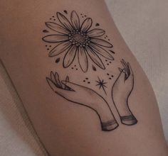 two hands holding a flower tattoo on the left arm and one hand with a star in it