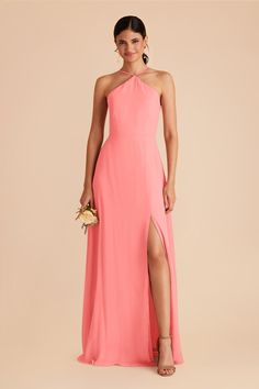 a woman in a long pink dress with one leg slited up and the other side split