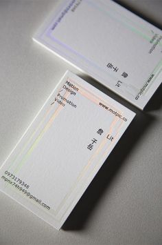 two white business cards sitting next to each other