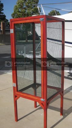 a red metal stand with a white boat in the background