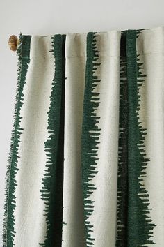 green and white striped curtains hanging on a curtain rod with a button at the end