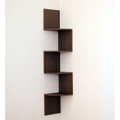 three wooden shelves on the wall with white walls