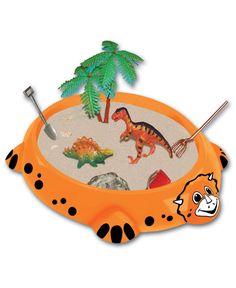 an orange and black toy tray with dinosaurs in the sand, palm trees and rocks