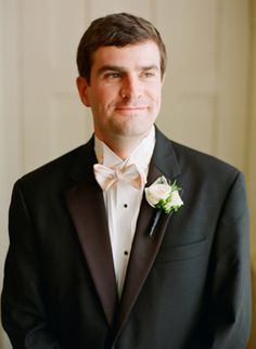 a man in a tuxedo smiles at the camera