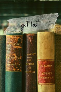 three old books sitting on top of a shelf with the words get lost written above them