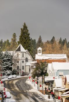 a small town with snow on the ground and trees in the backgrouds