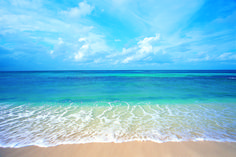 an ocean view with waves coming in to the shore and blue sky above, on a sunny day