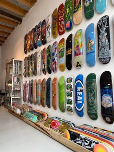 there are many skateboards hanging on the wall