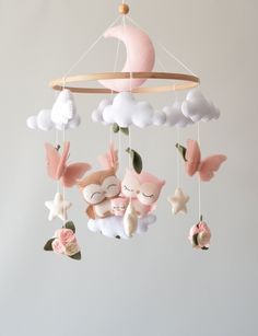 a mobile with stuffed animals hanging from it's sides in the shape of a moon and clouds