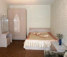 a bedroom with a bed, dresser and mirror in it's center area is shown