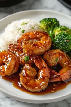 a white plate topped with shrimp and broccoli covered in teriyaki sauce