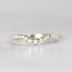 a three stone diamond ring in yellow gold with white diamonds on the band and side stones