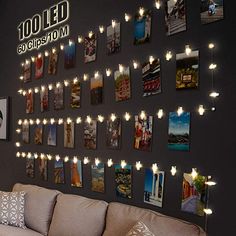 a living room filled with lots of lights and pictures on the wall next to a couch