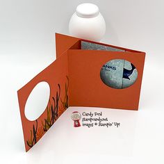 an open card with the image of a bird on it and a vase behind it